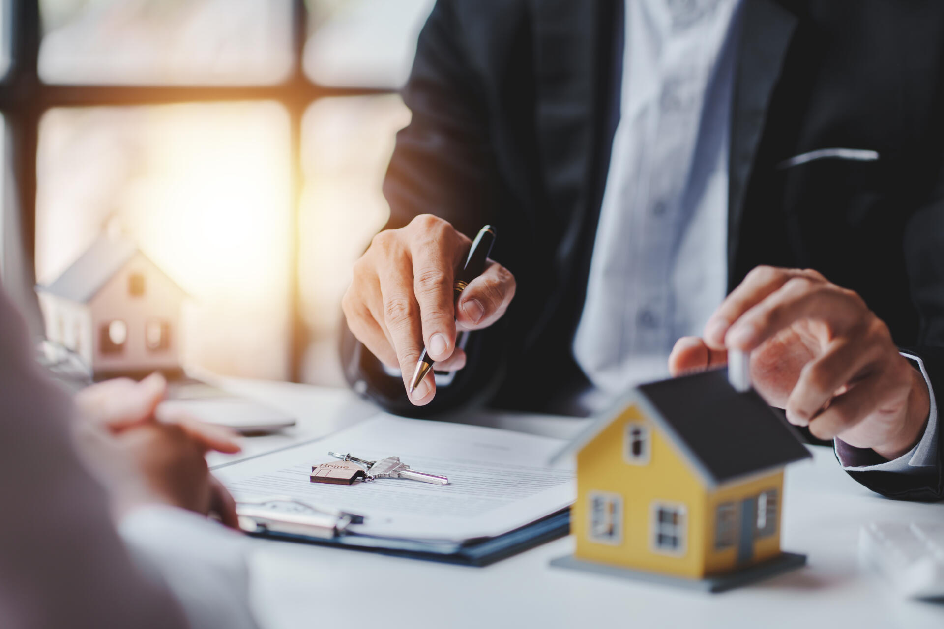 Ein Mann zeigt auf ein Miniaturhaus