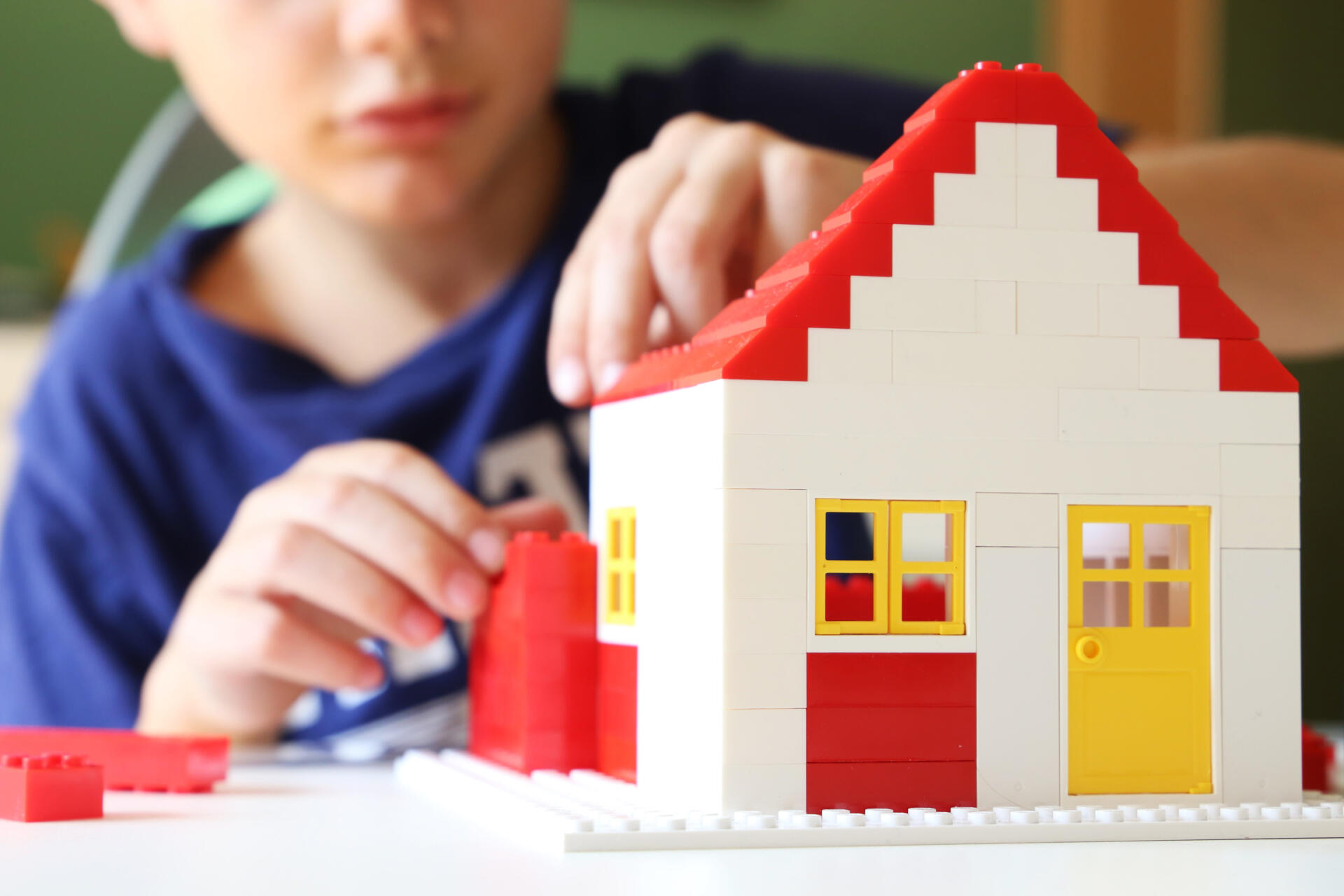 Junge baut Haus aus Lego