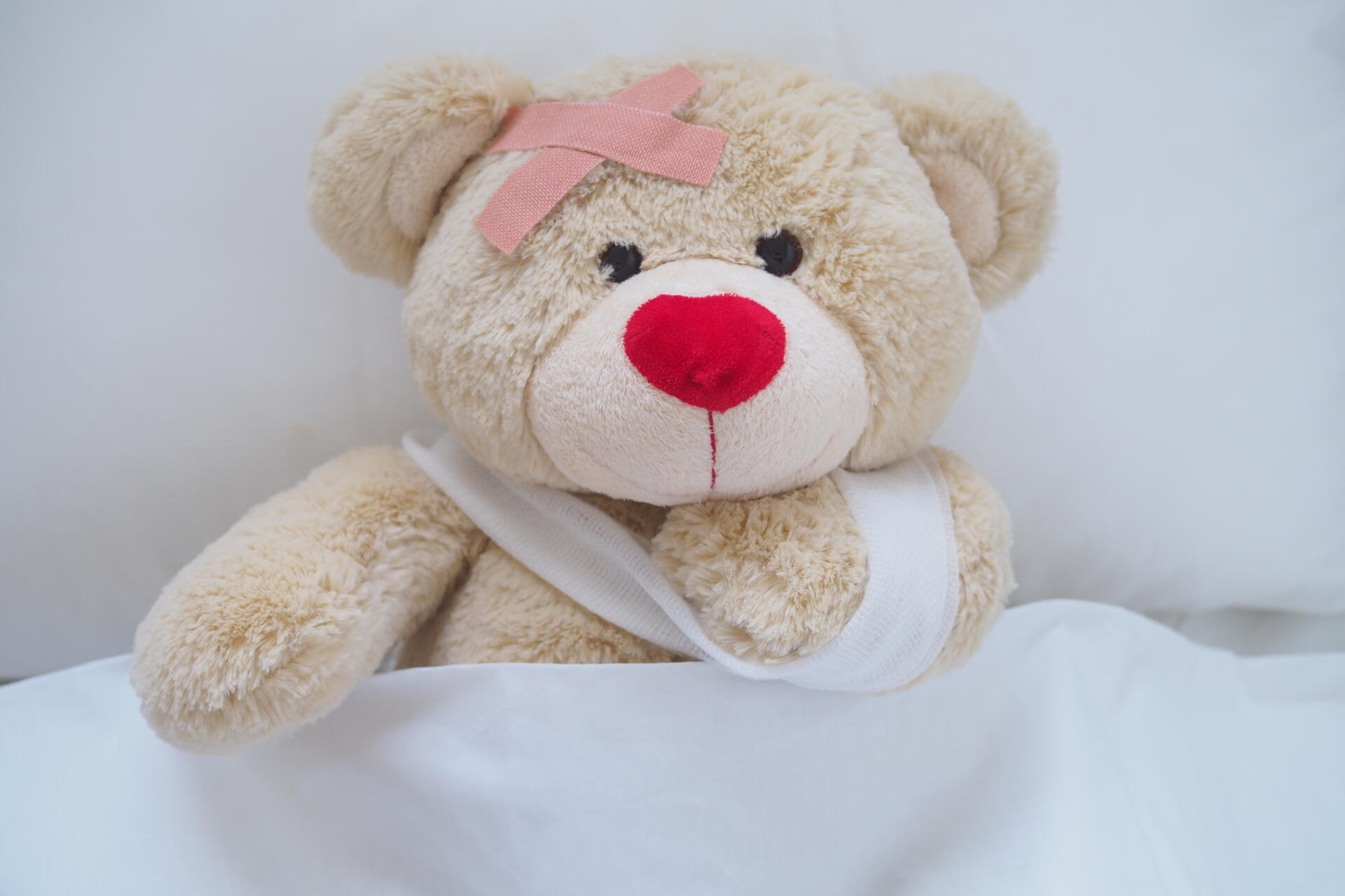 Teddybär mit Bandage und Pflaster auf dem Kopf